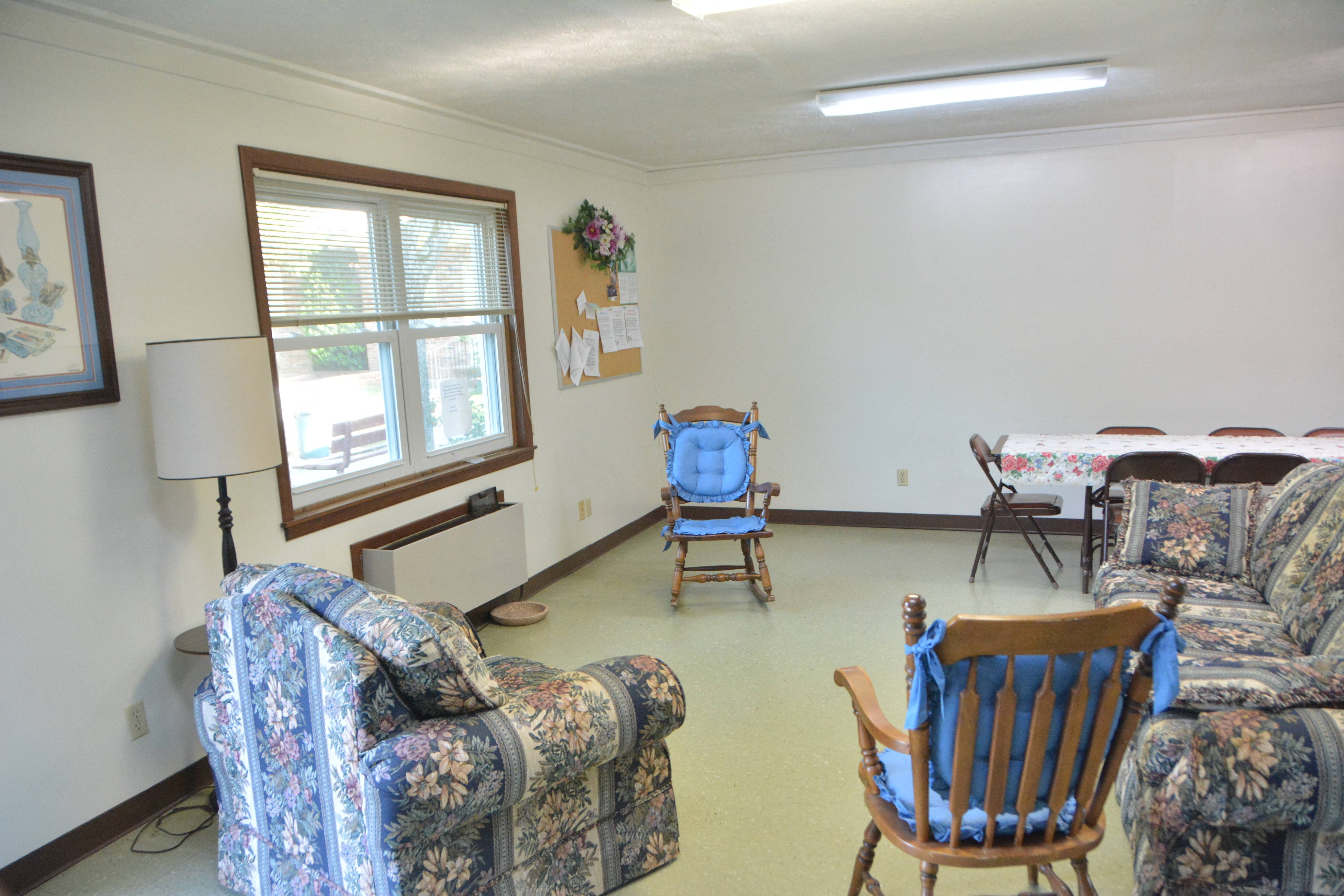 a living room with couches and chairs and a table with a bed